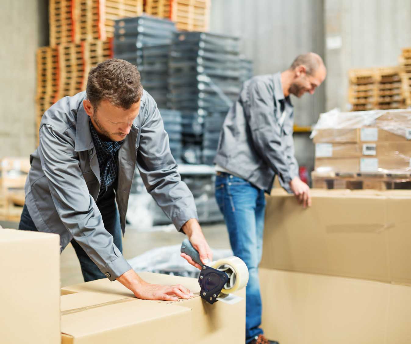 Two men package boxes