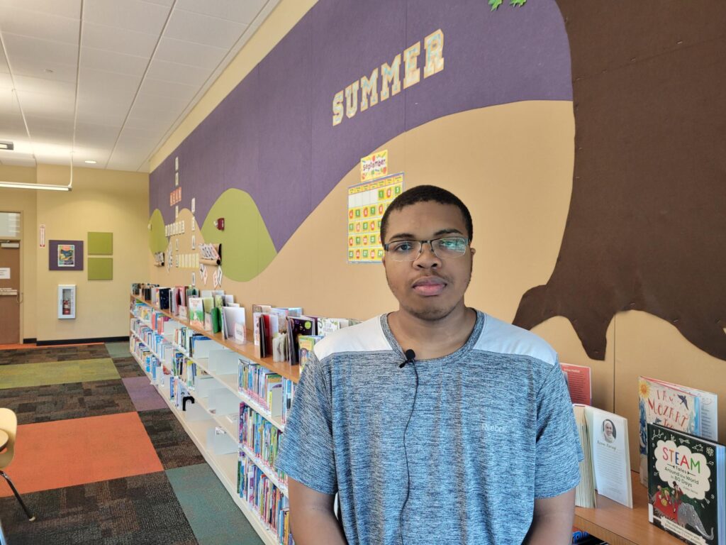 Man standing in a library looking at the camera