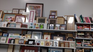 Shelf at Goodwill with home decor items and books